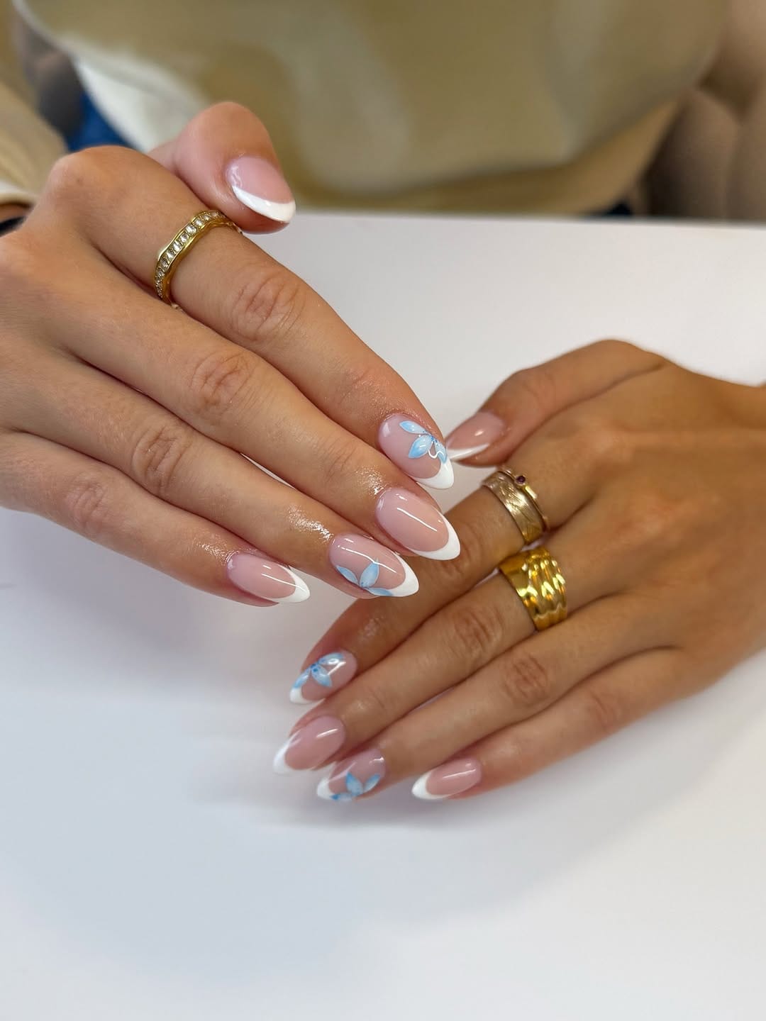 Almond French tips with blue floral details.