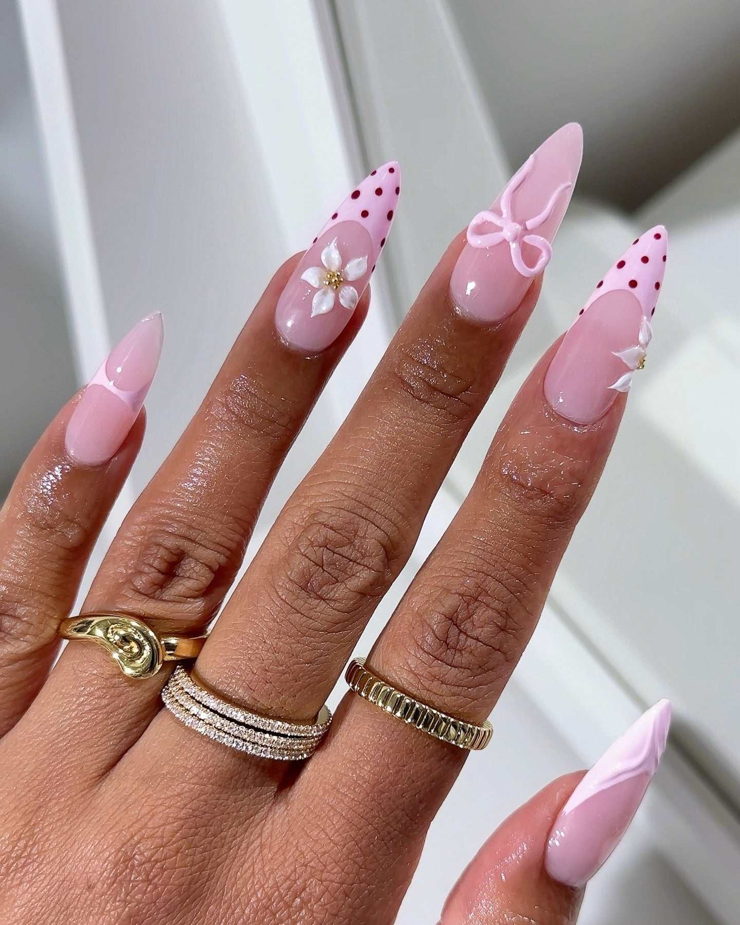 Stiletto pink polka dot French nails.