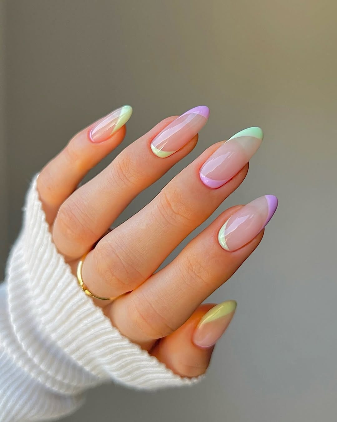 Almond pastel rainbow French tip nails.