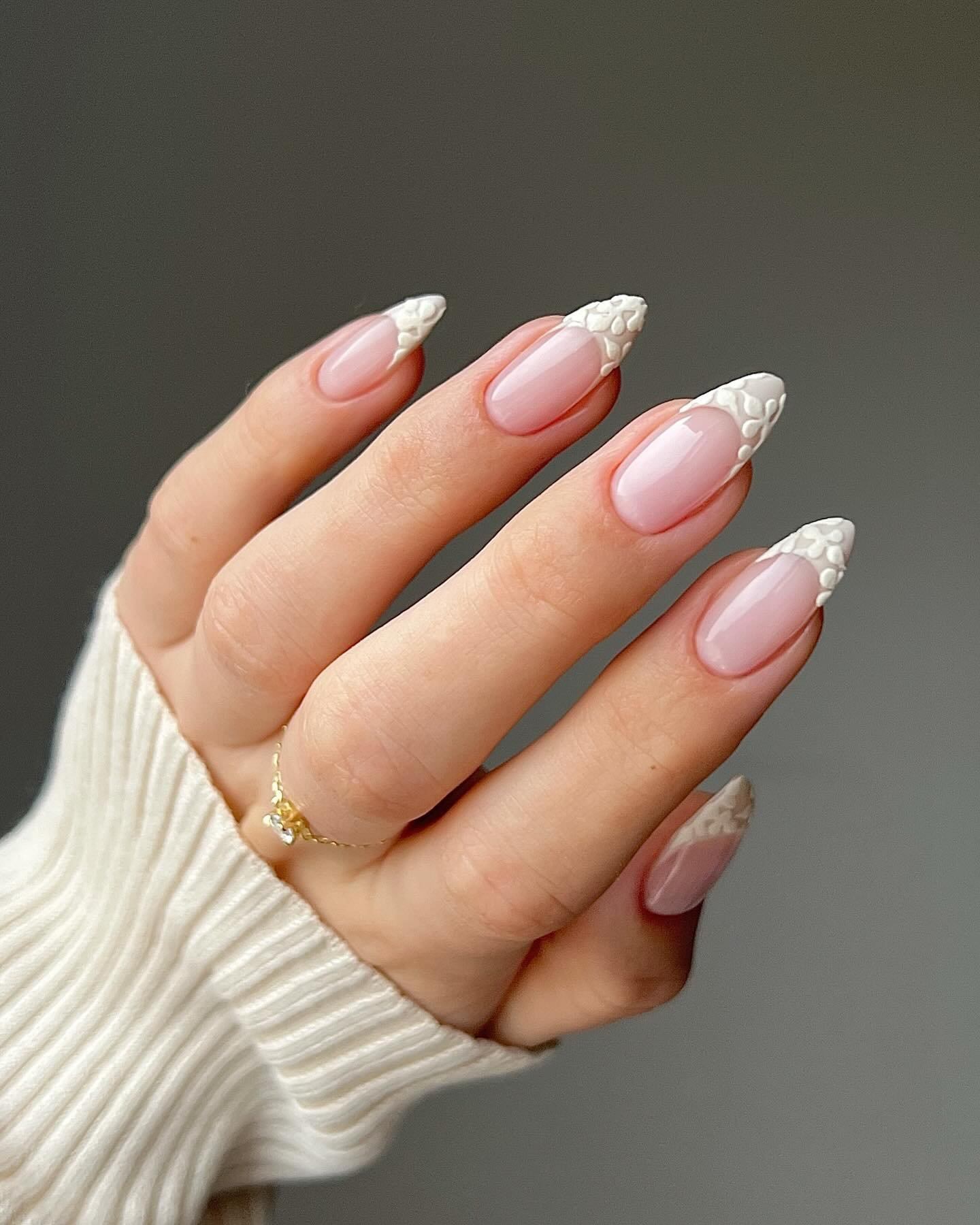 Almond textured white floral French tip nails.