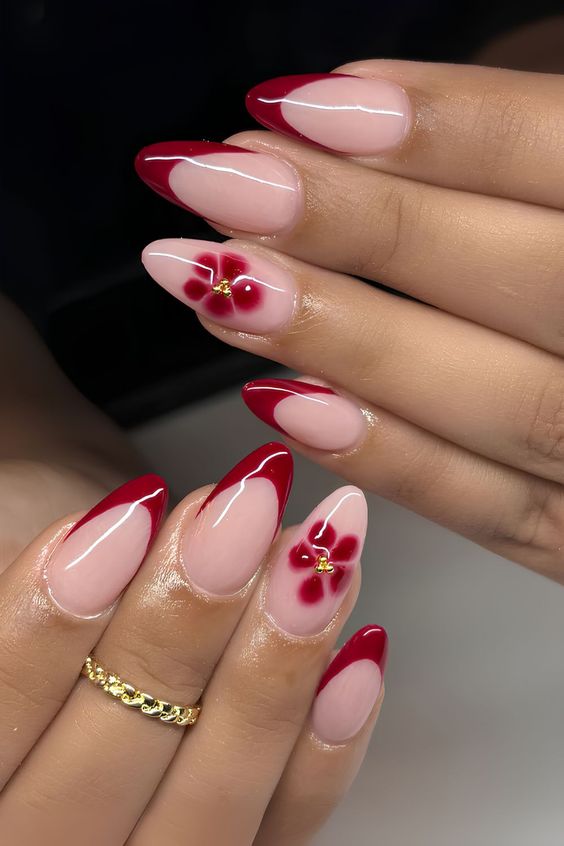 Almond red floral French tip nails.