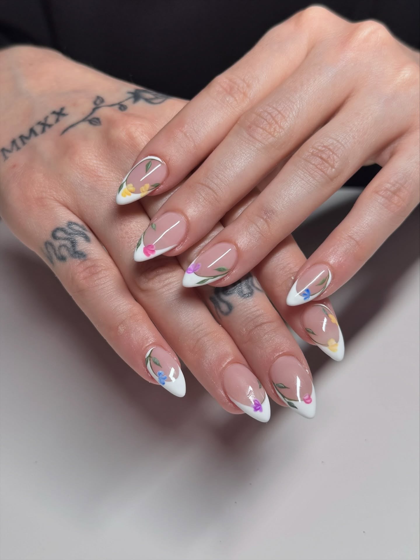 Almond white floral French tip nails.