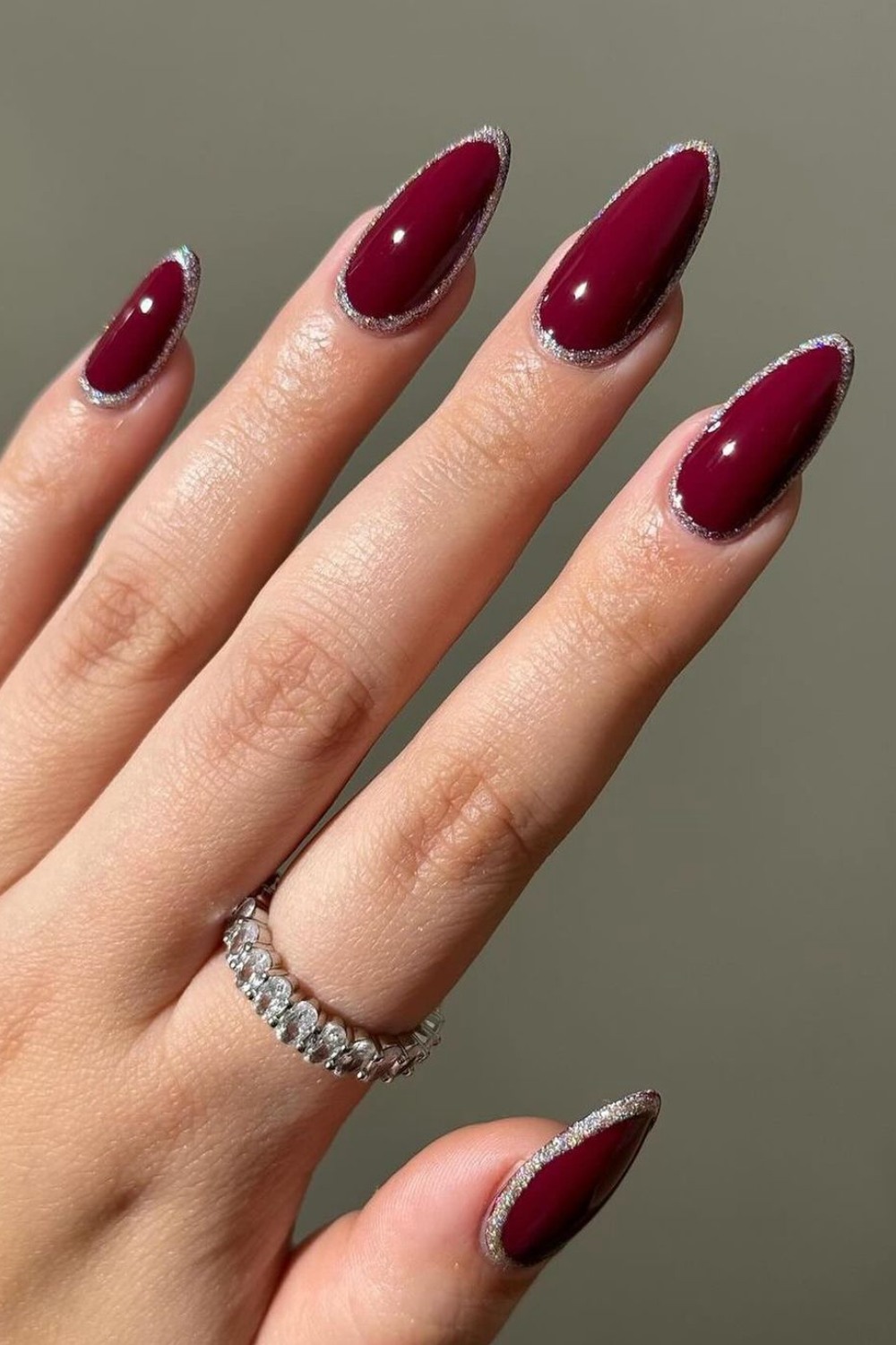 Burgundy nails with silver glitter edges, sophisticated and modern.