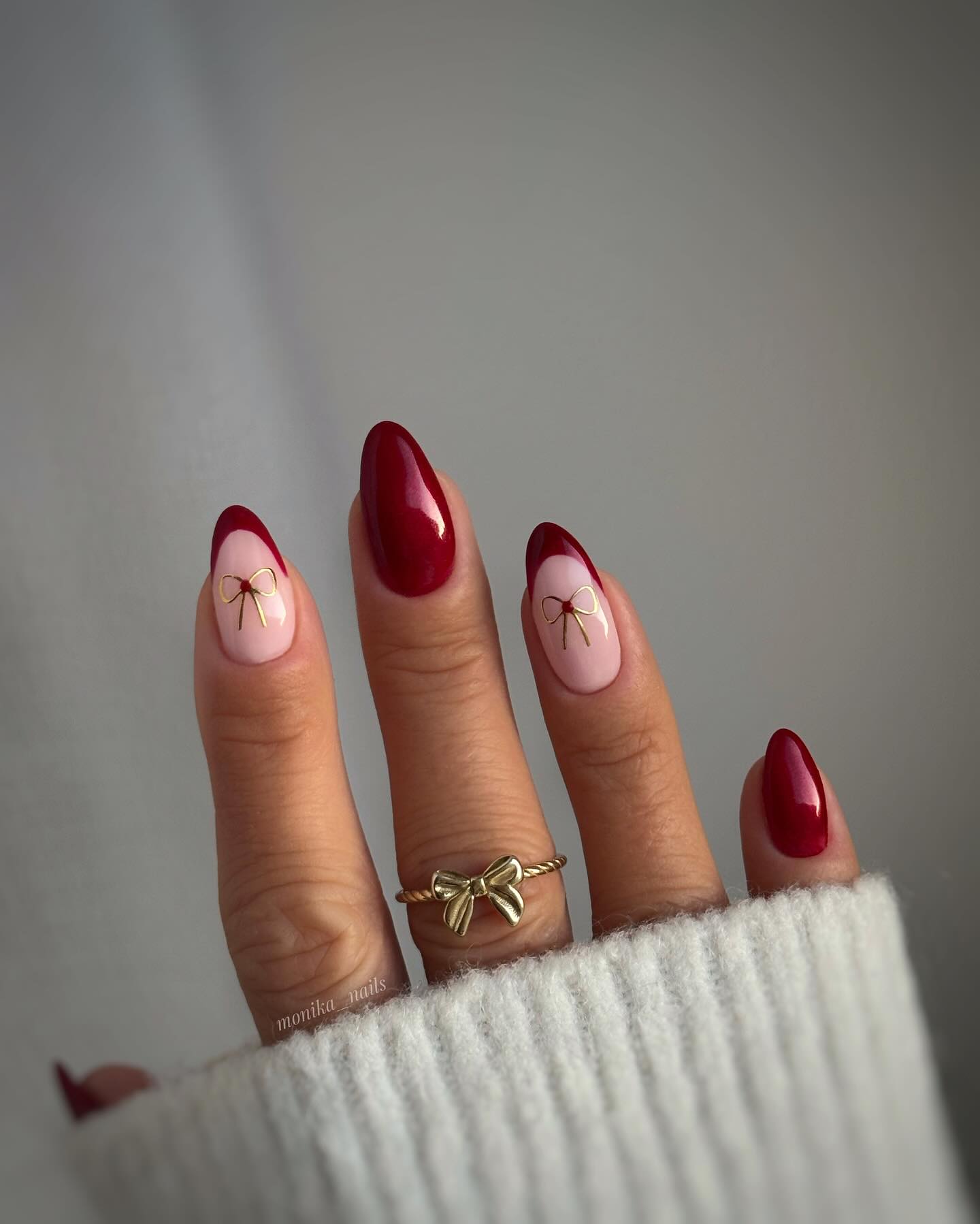 Cherry red nails with delicate bow accents, sweet and feminine.