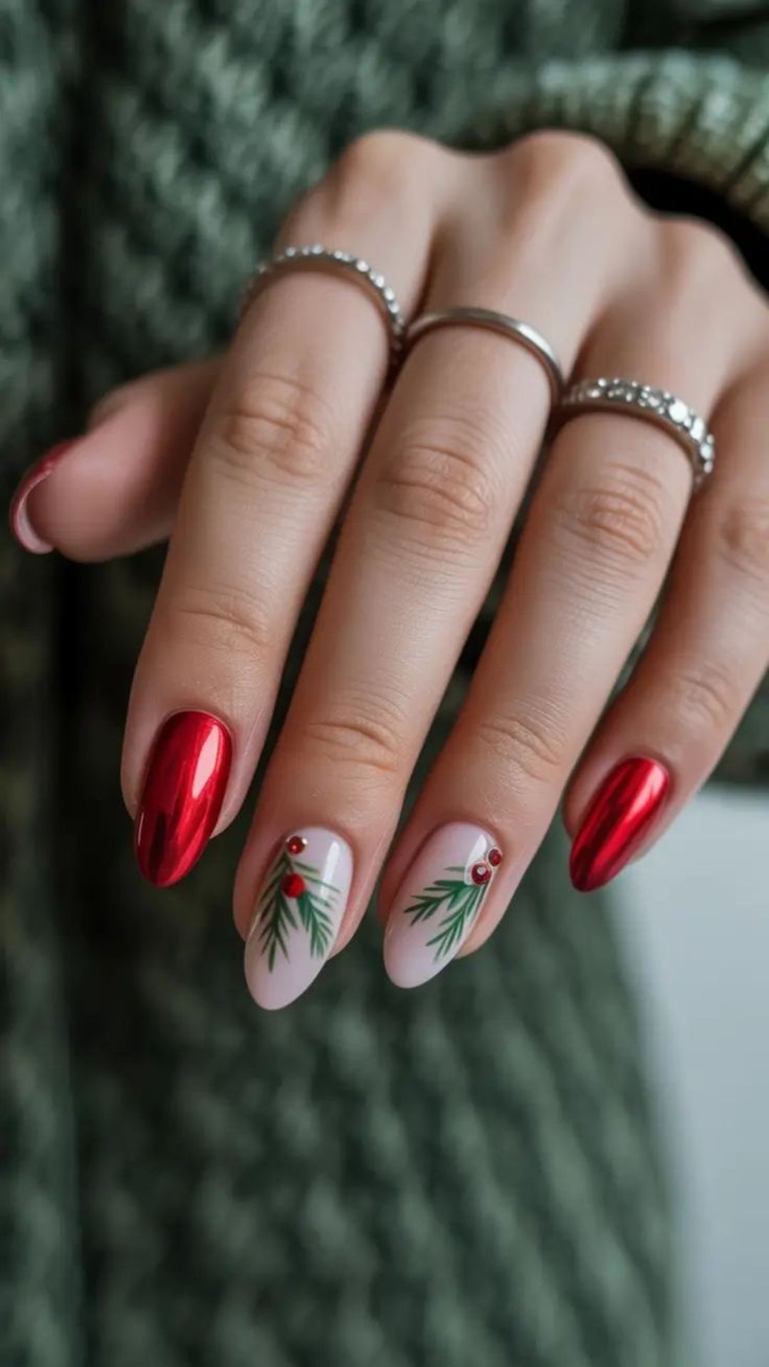 Red nails with evergreen and berry art, holiday-themed and elegant.