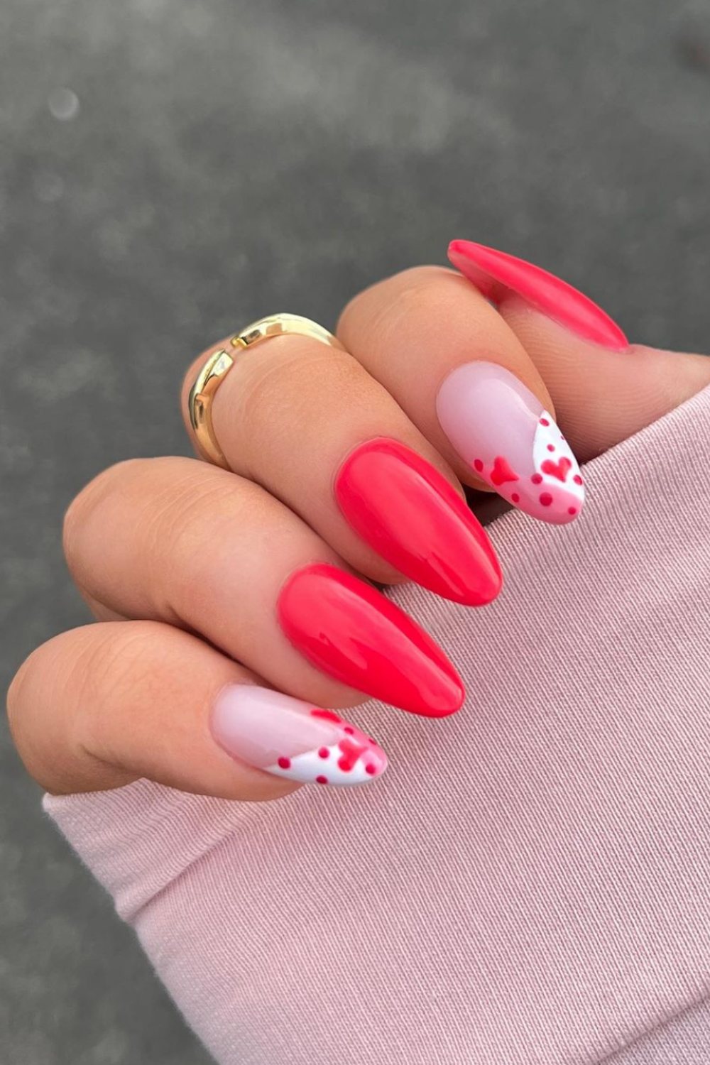 Vibrant red nails with playful white dot accents, fun and modern.