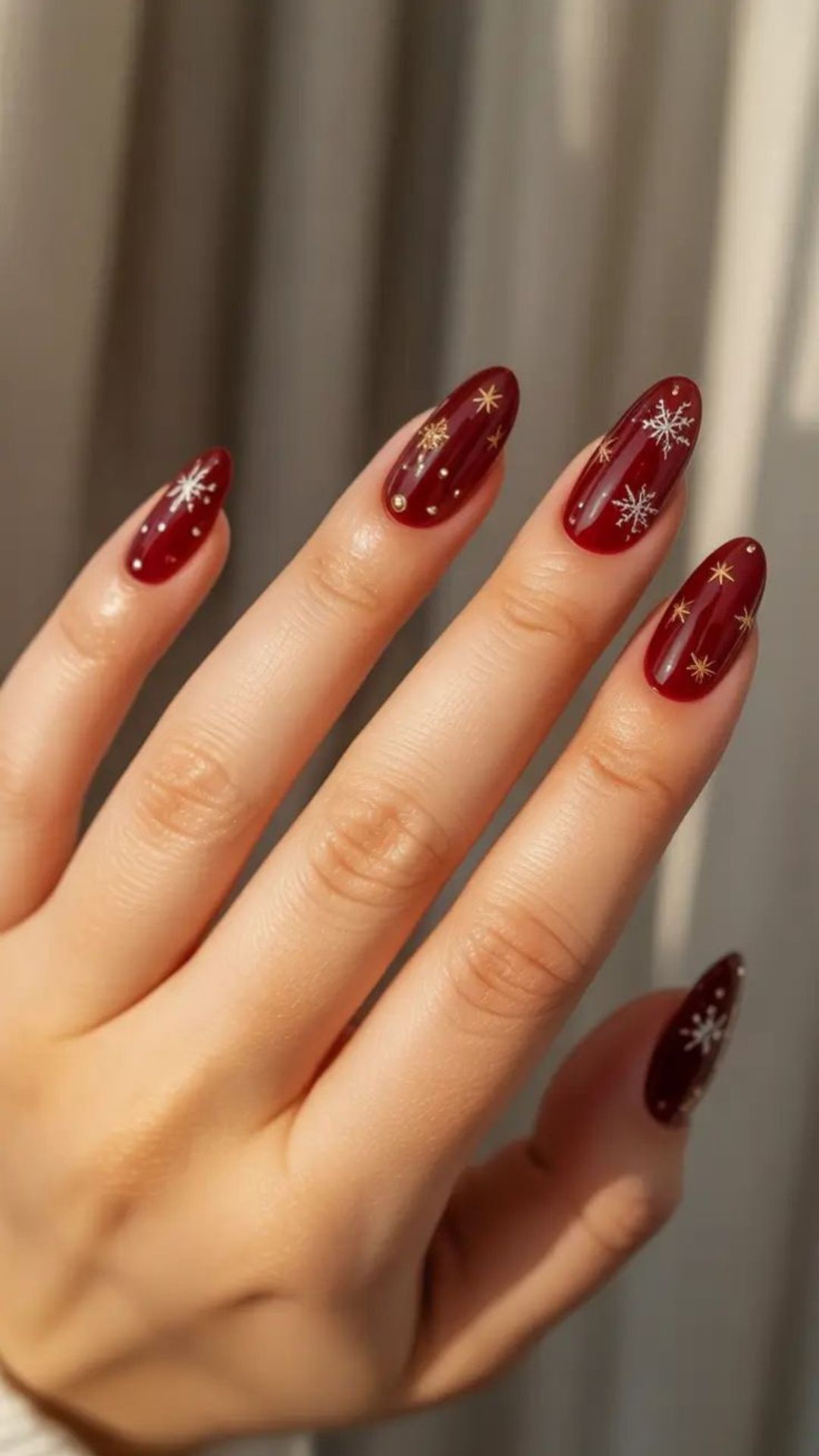 Festive maroon nails with star accents, warm and elegant.