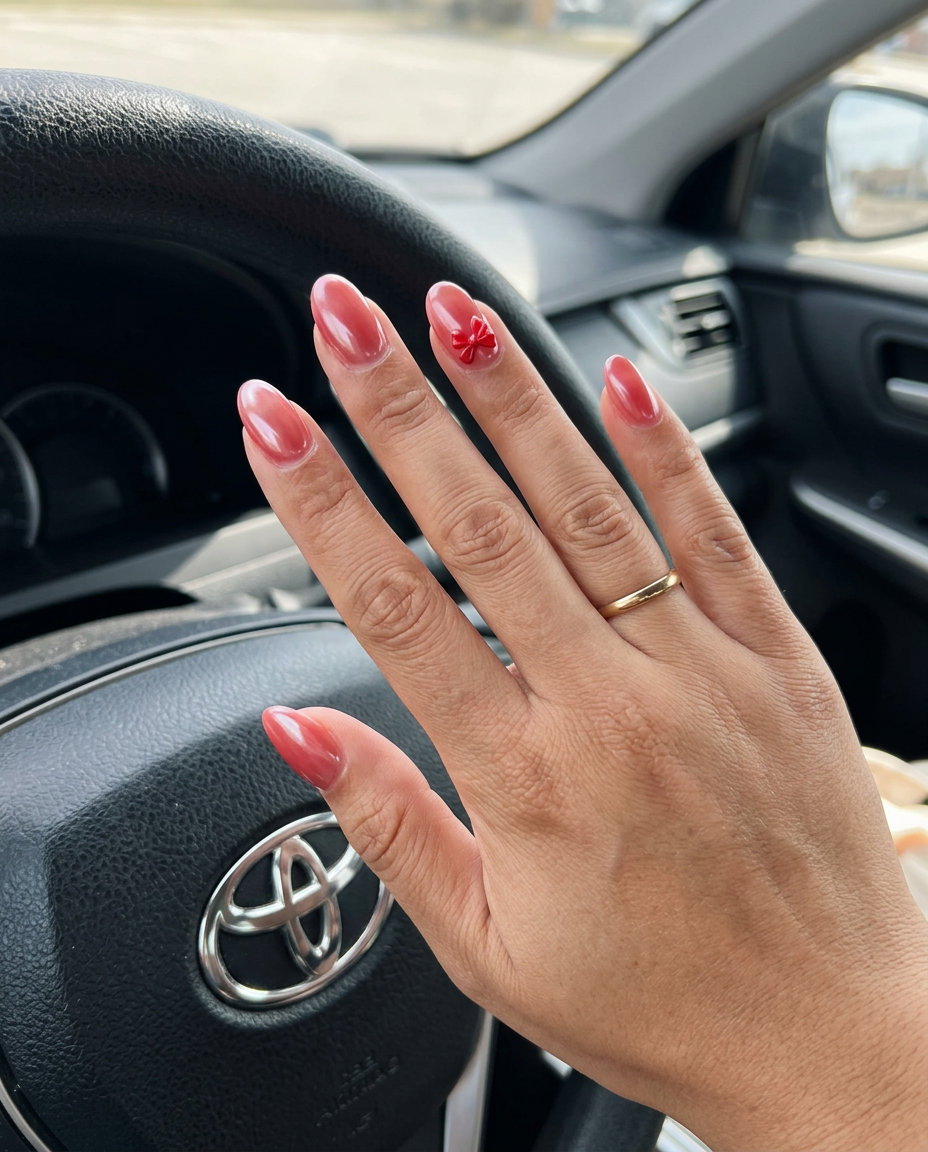 Chic red nails with bow accent, cute and stylish.