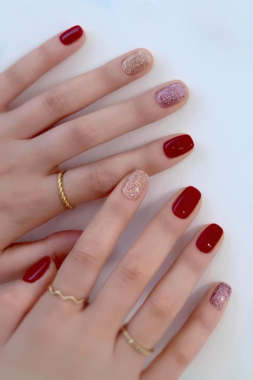 Red nails with gold glitter accents, festive and glamorous.