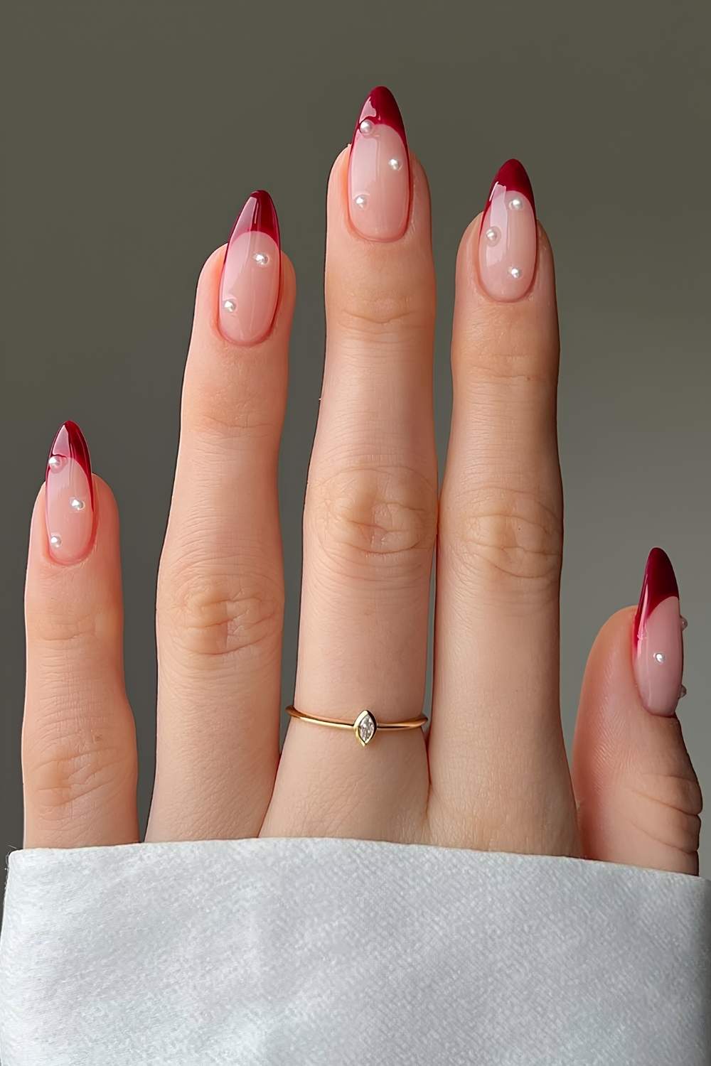 Red French tips with pearl accents, elegant and chic.