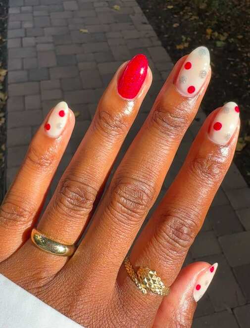 Red polka dot nails with almond shape, fun and trendy.