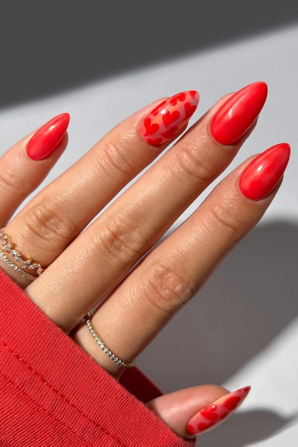 Red nails with heart accents, playful and romantic.