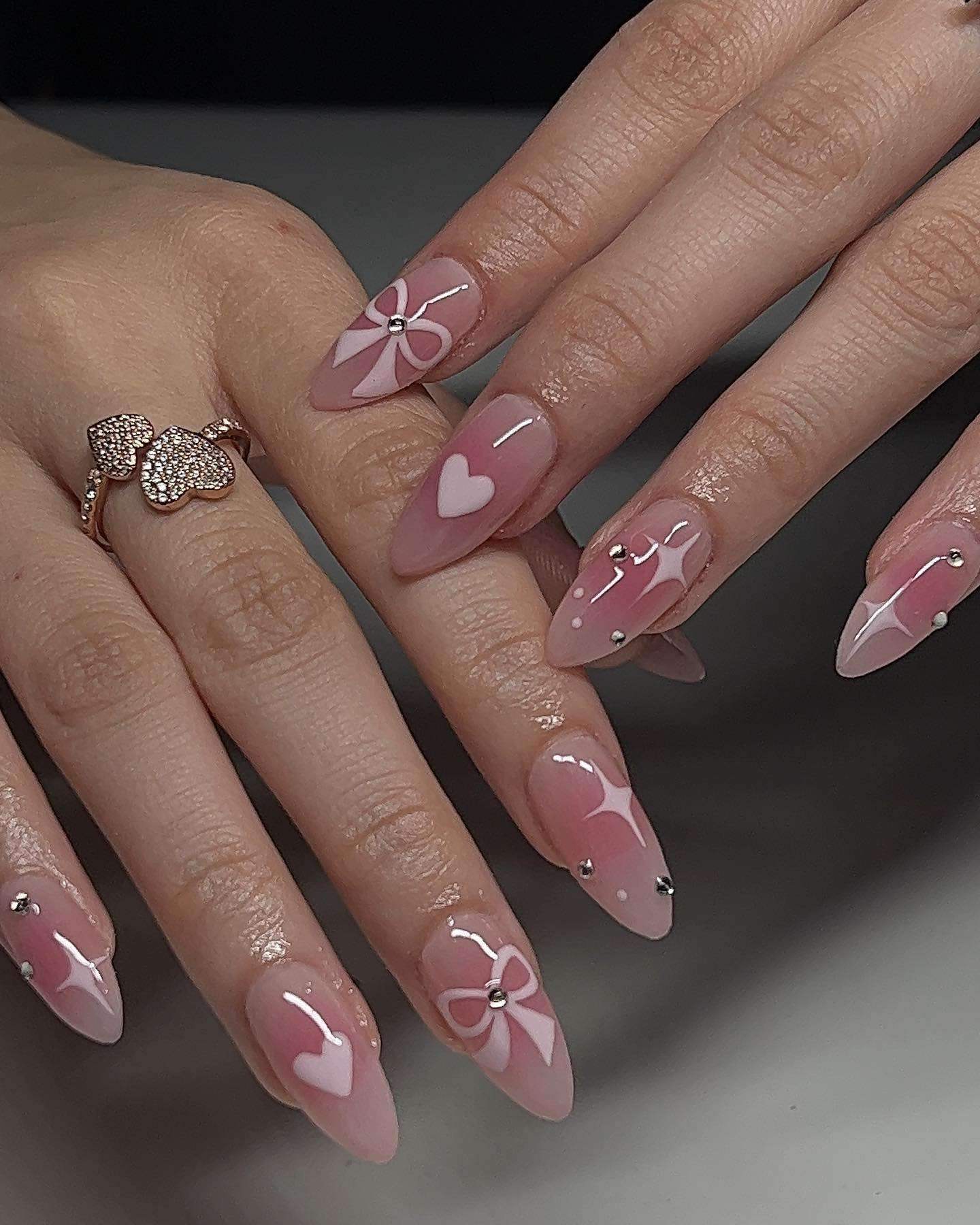 Pink stiletto nails with bows and hearts