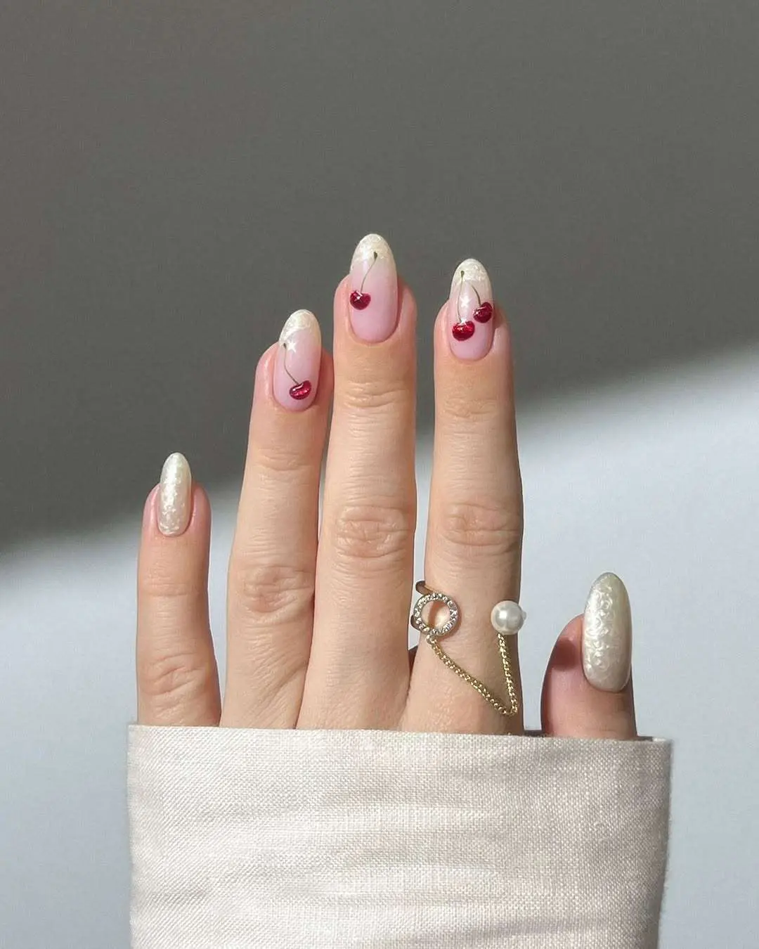 Pearl nails with red heart accents on oval shape