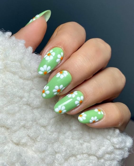 Green nails with white daisy art in almond shape