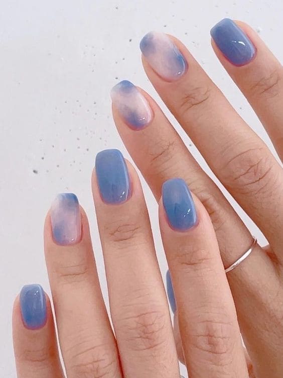 Blue ombre nails with blue and brown nails, greece nails, and white milky finish