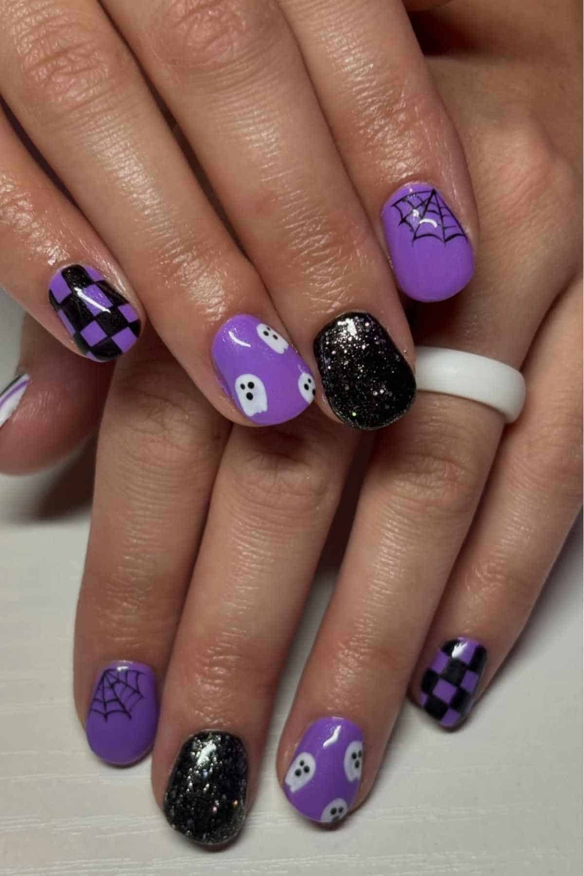 Purple and black nails with ghosts and spider webs