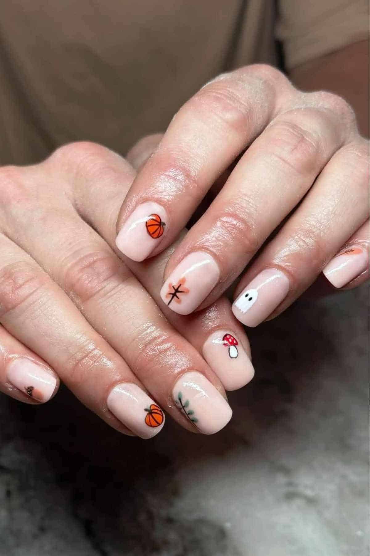 Nude nails with pumpkins and autumn motifs
