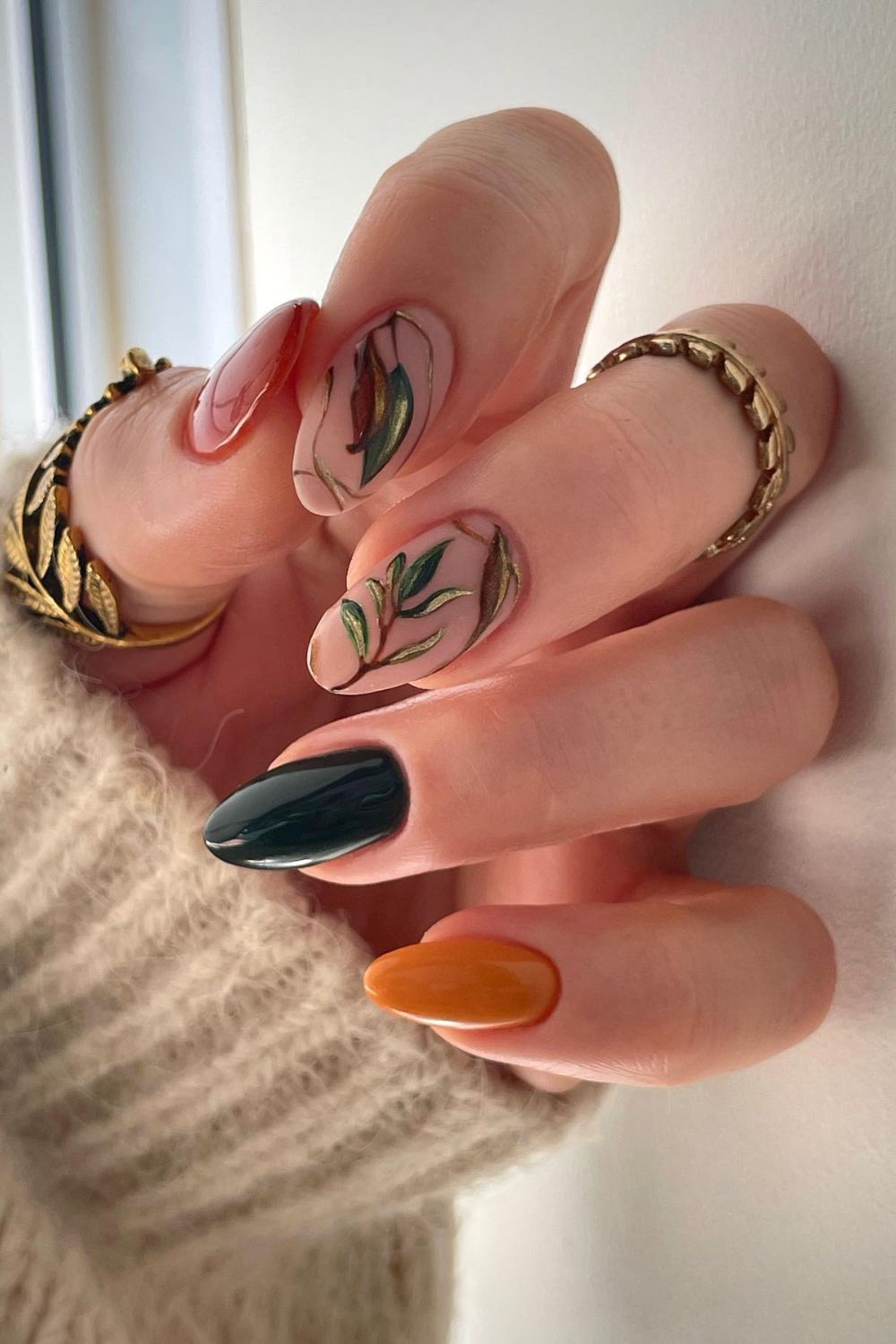 Earthy nail art with leaves and solid colors