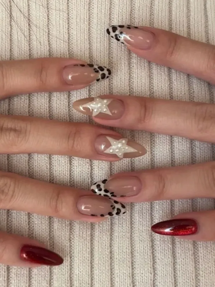 Animal print nails with pearl accents on almond shapes.