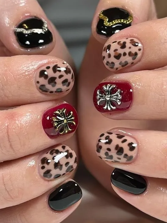 Leopard print nails with statement gem accents.