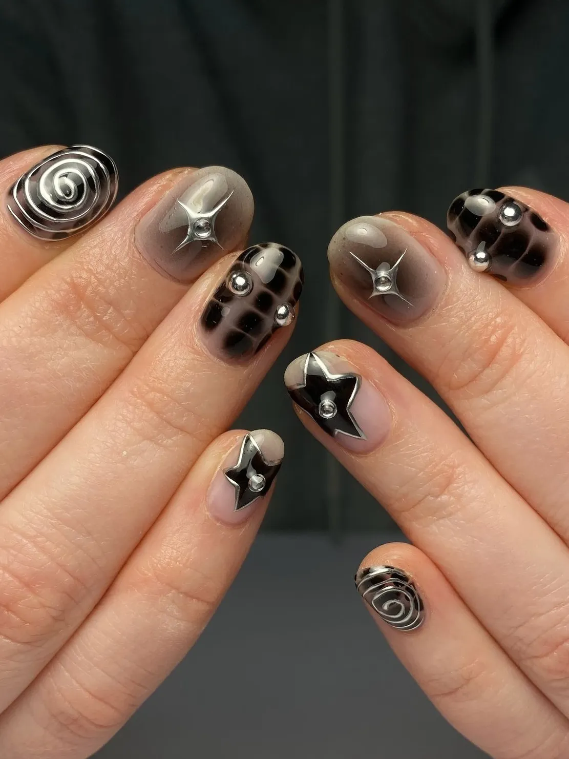 Monochrome nails with metallic star accents.