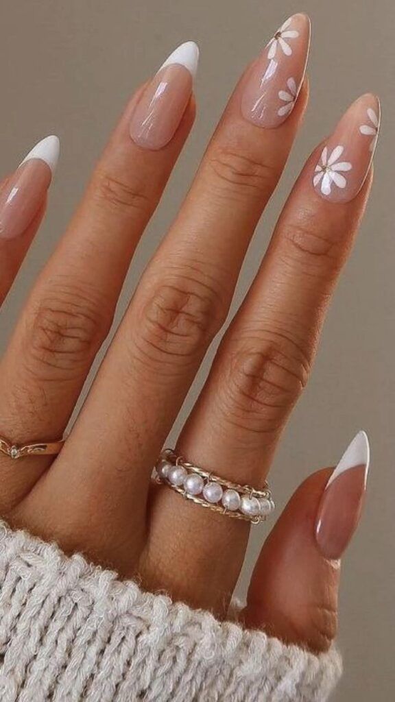 French tip nails with white floral designs.
