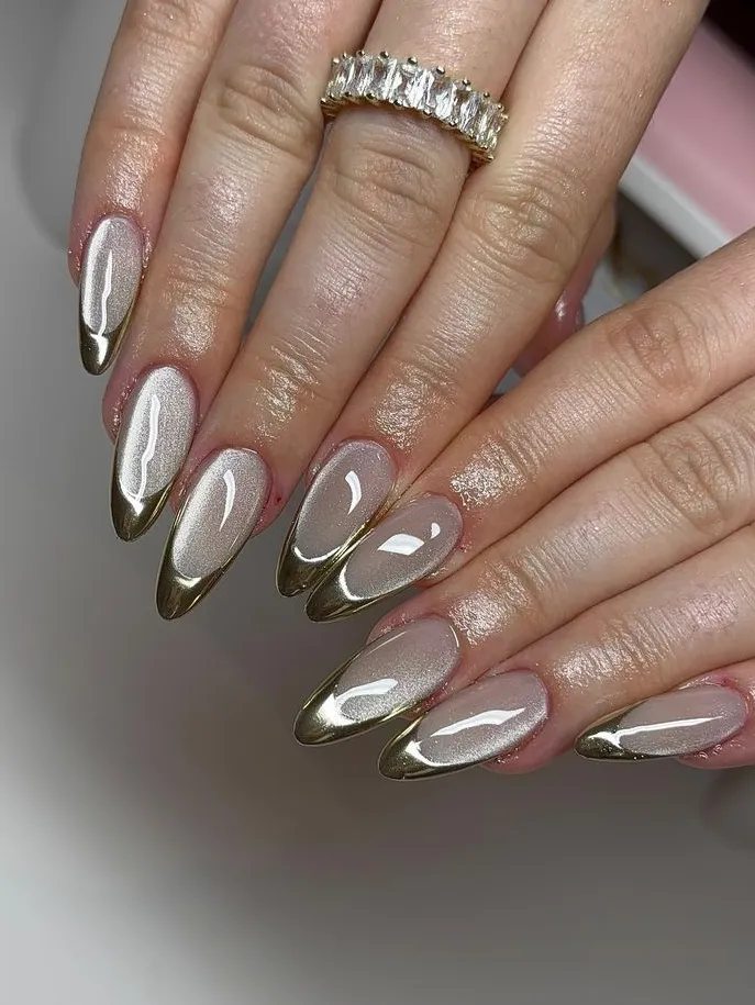 Nude nails with gold tips on an almond shape.