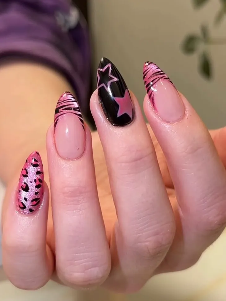 Graphic pink and black nails with stars on stiletto shape.
