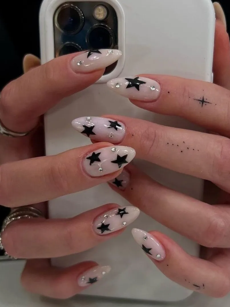 Almond nails with black star accents.