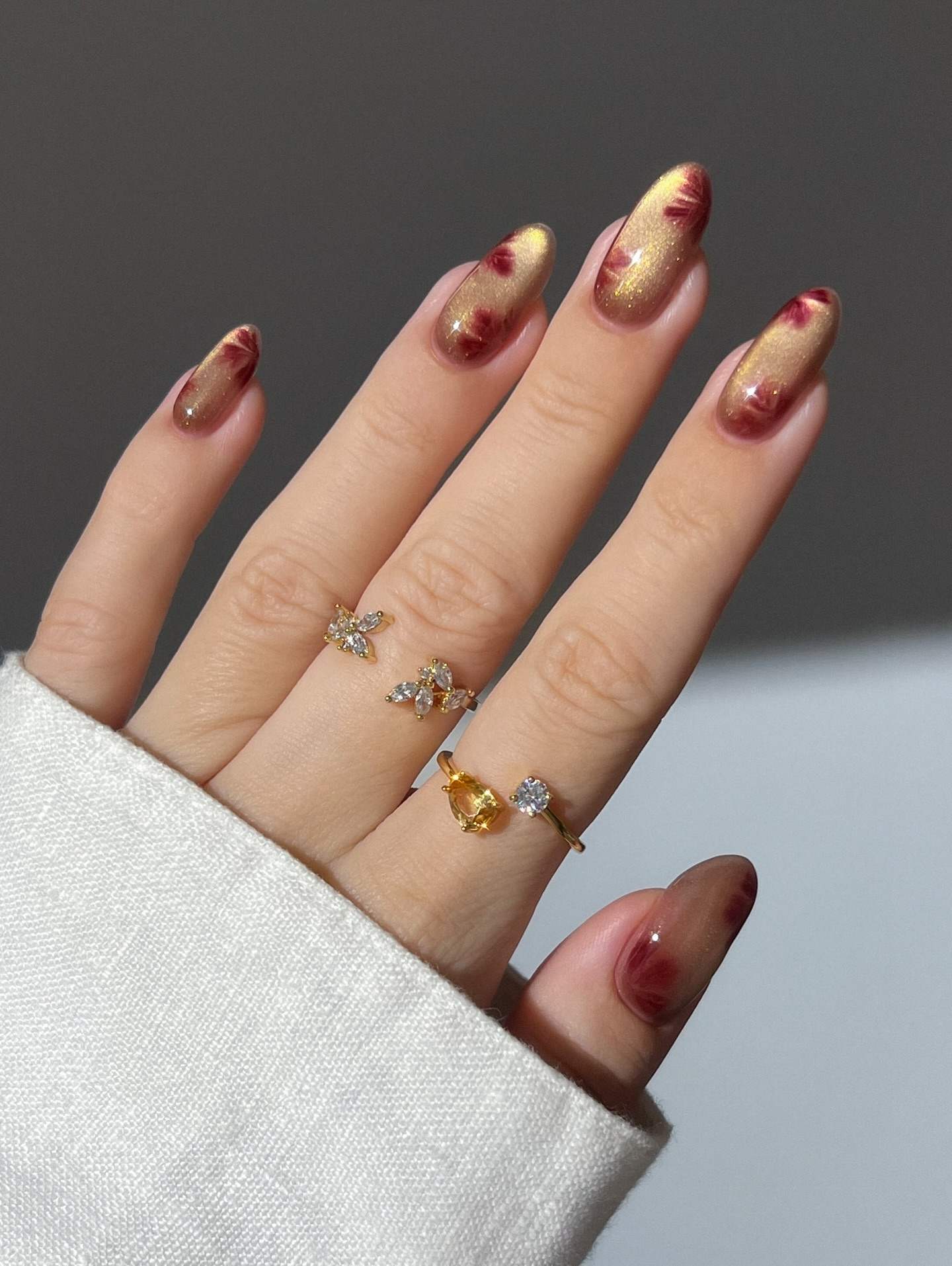 Golden almond nails with autumn leaf patterns