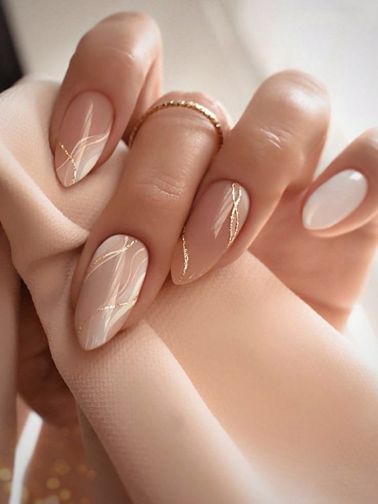 Nude almond nails with gold vein accents