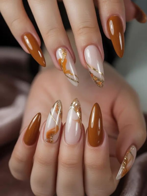 Long almond nails with caramel and gold swirl, stylish fall nails