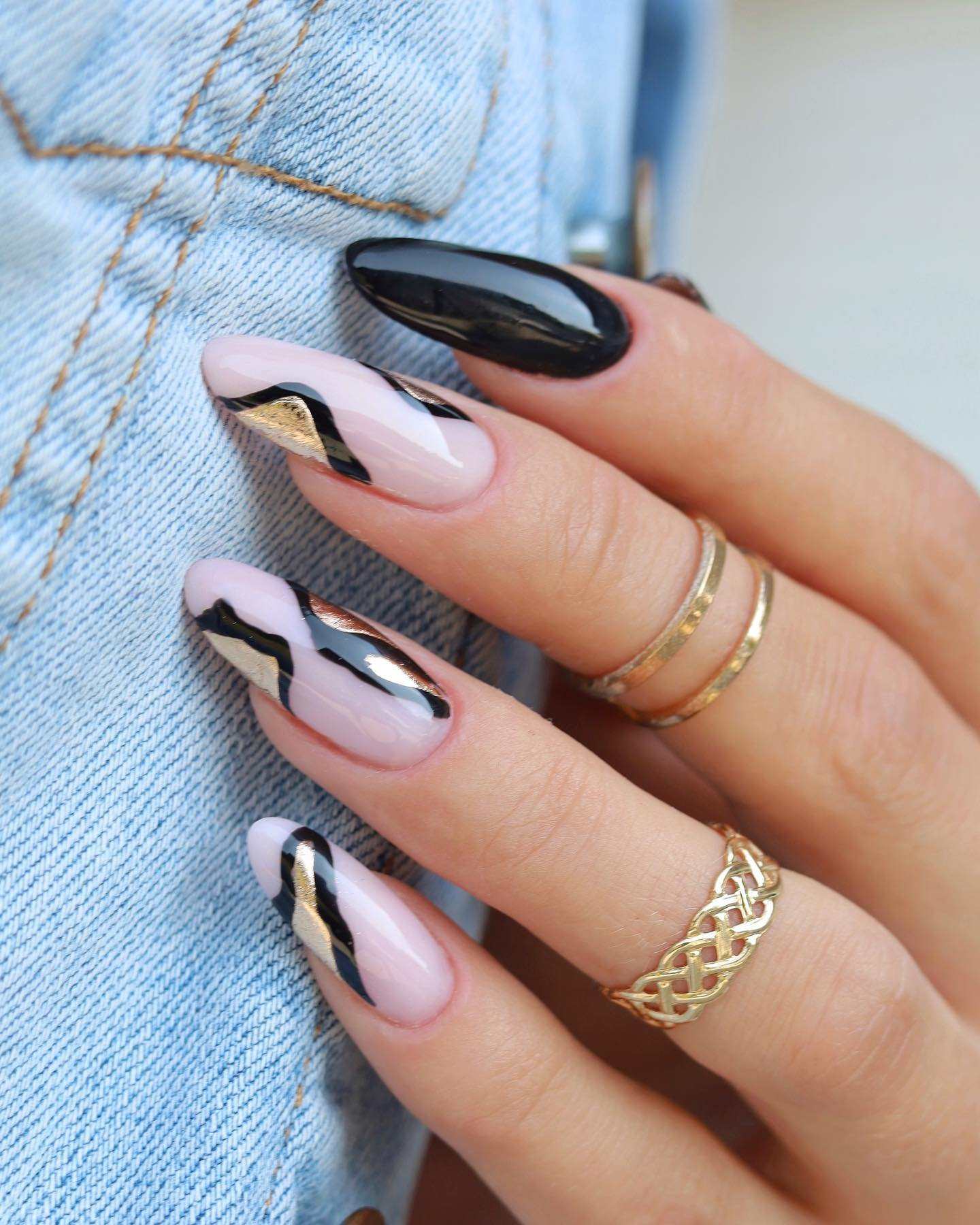 Almond nails with black, nude, and gold geometric design