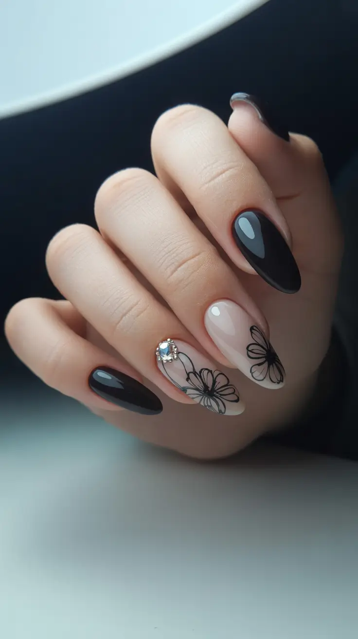 Black almond nails with floral accent and rhinestone