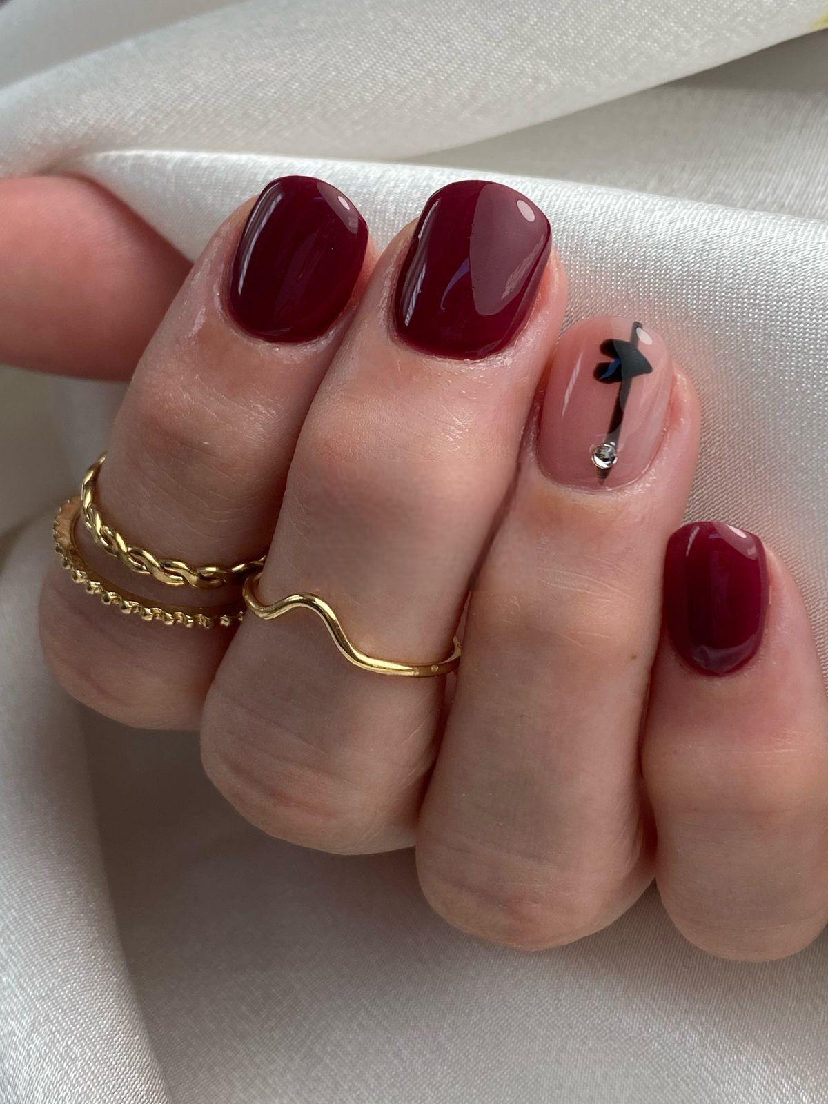 Minimalist burgundy nails with artistic flourish, nail art simplicity