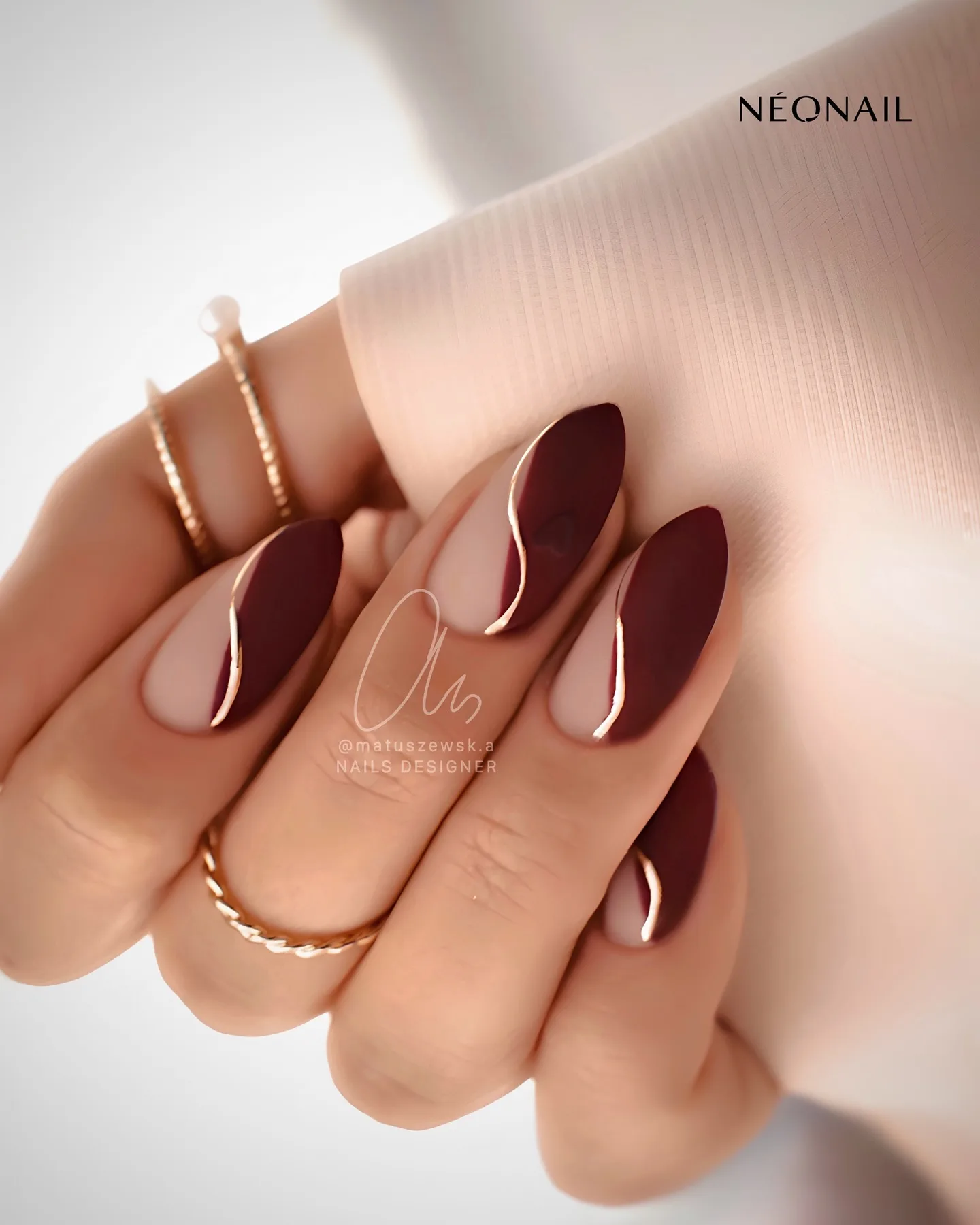 Burgundy nails with metallic accent, chic elegance