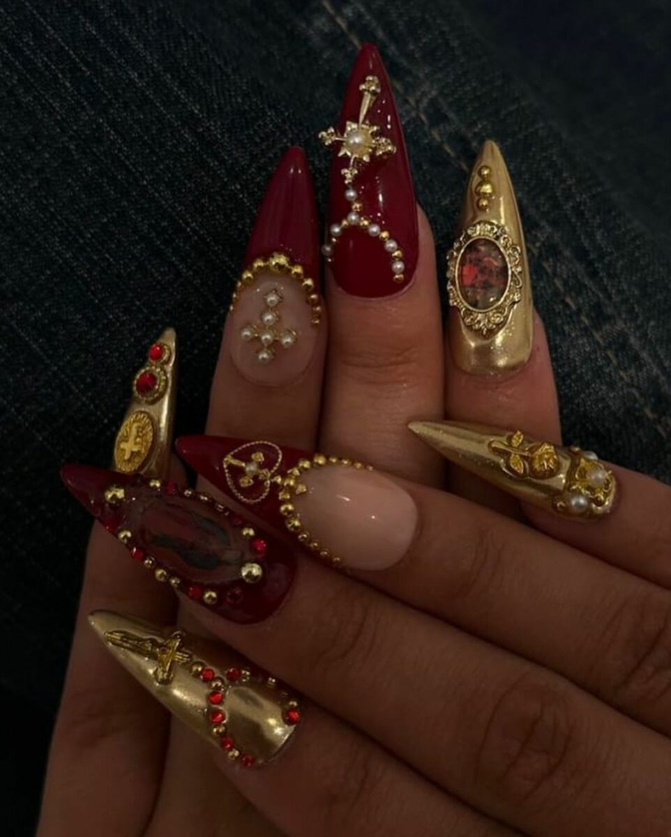 Opulent burgundy nails with gold embellishments, luxurious style