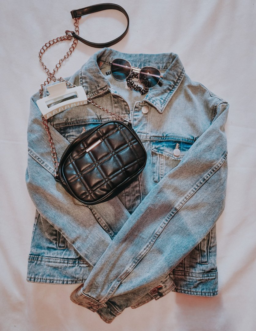 Denim jacket with quilted bag and sunglasses