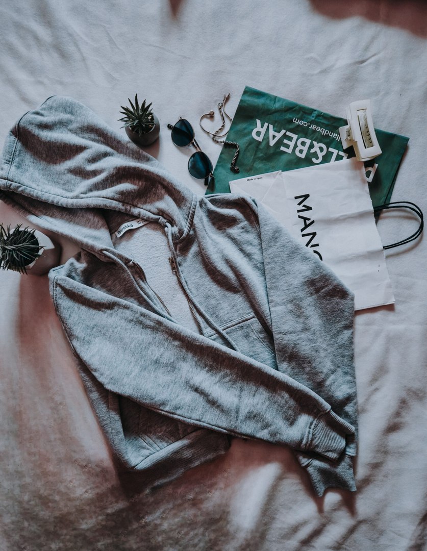 Grey hoodie laid with accessories