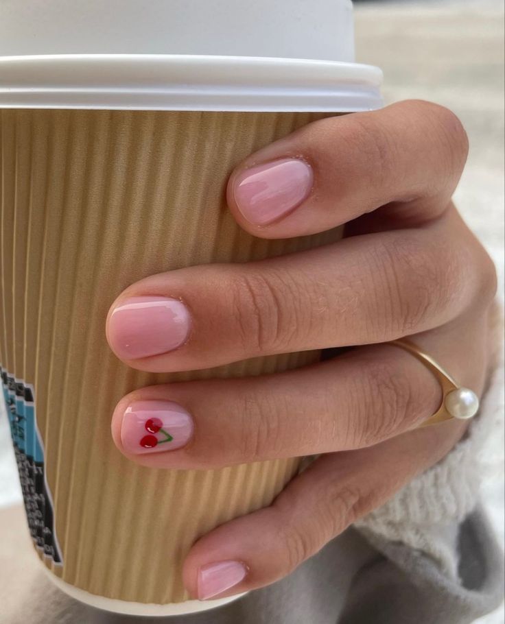 Short nails with cherry accent on pink base