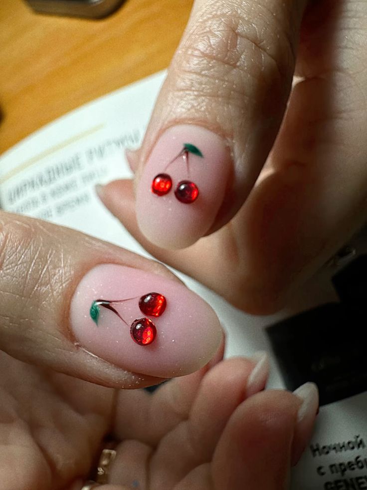 Short oval nails with nude base and glitter cherry art