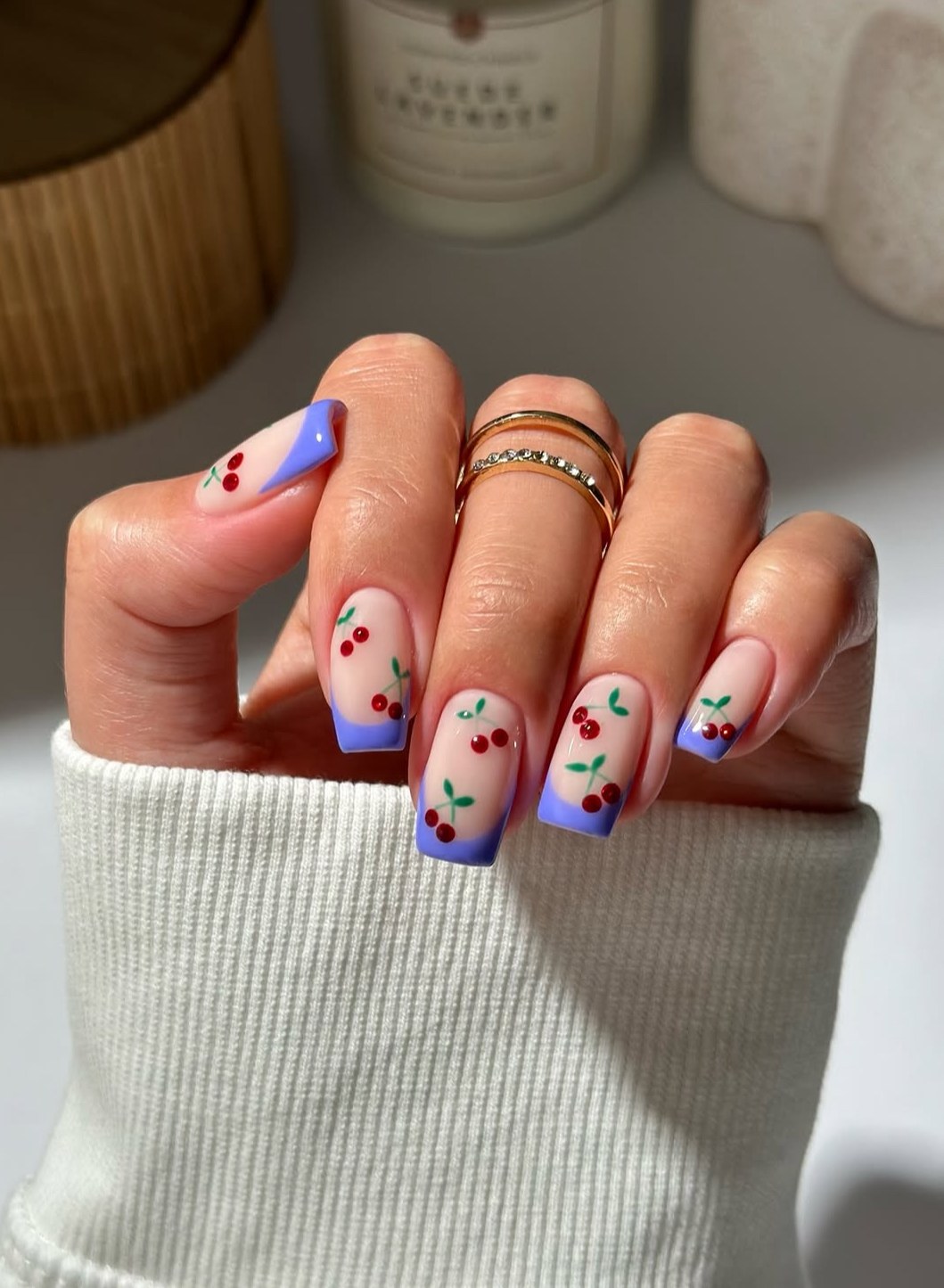 Square nails with blue French tips and cherry art