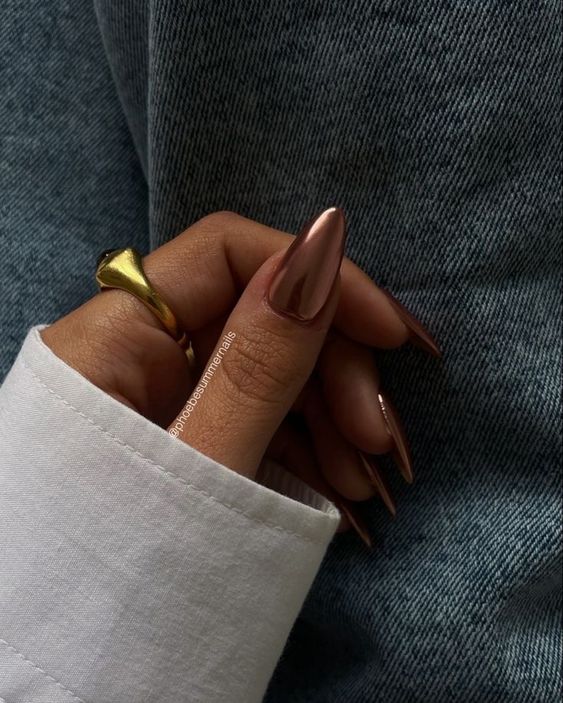 Metallic rose gold almond nails, luxurious fall shine.