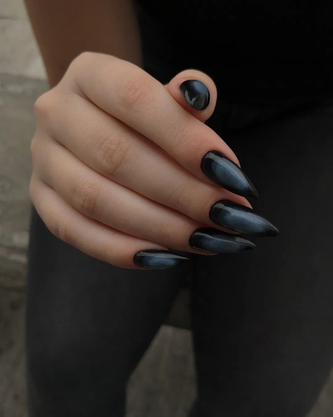 Black stiletto nails with chrome tips, edgy fall style.