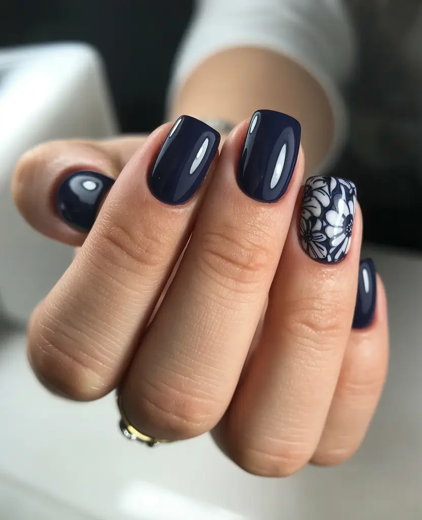 Midnight blue nails with floral accent, elegant fall choice.