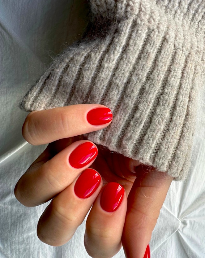 Vibrant red nails, oval shape, glossy, statement look