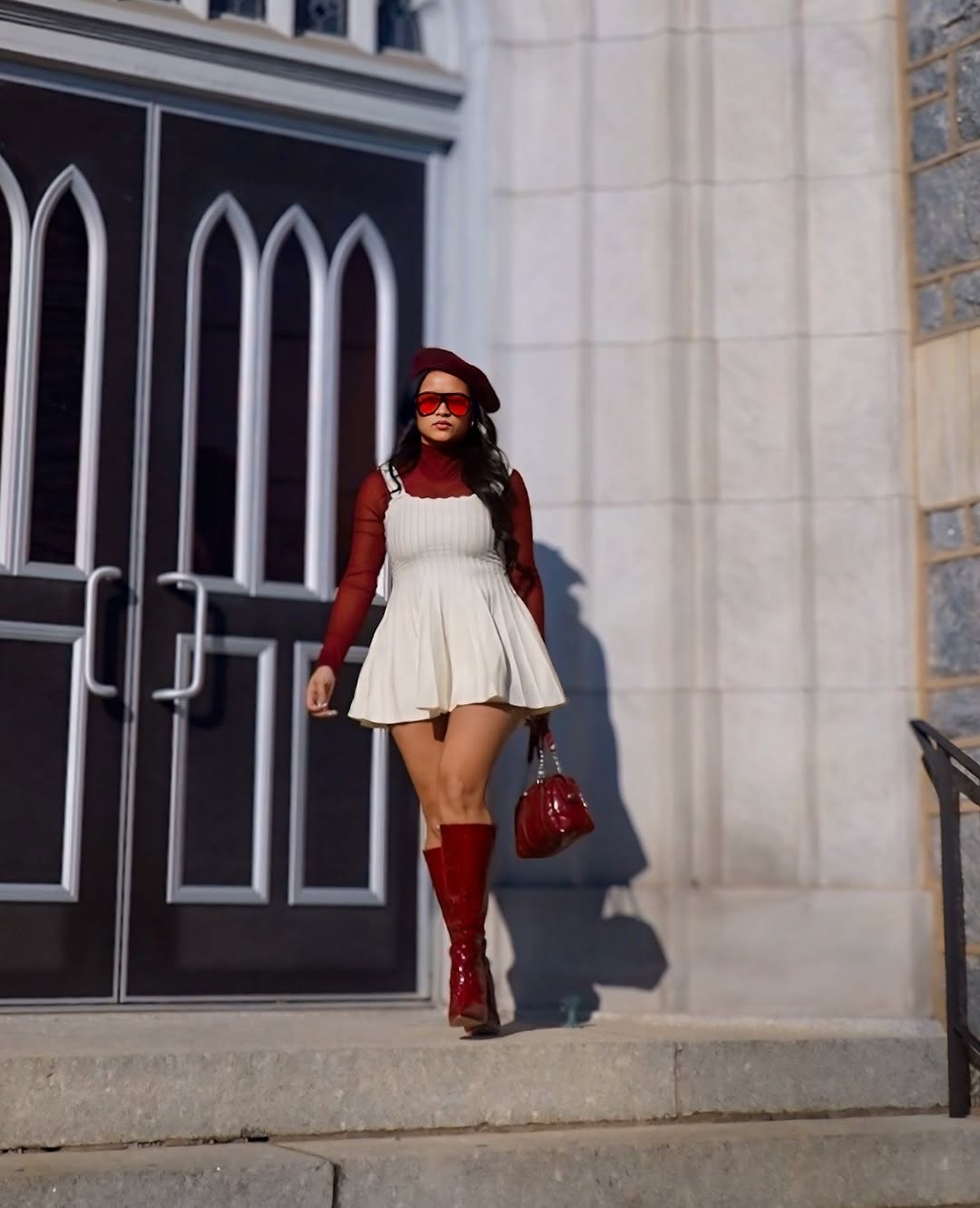 White pinafore with red turtleneck and boots