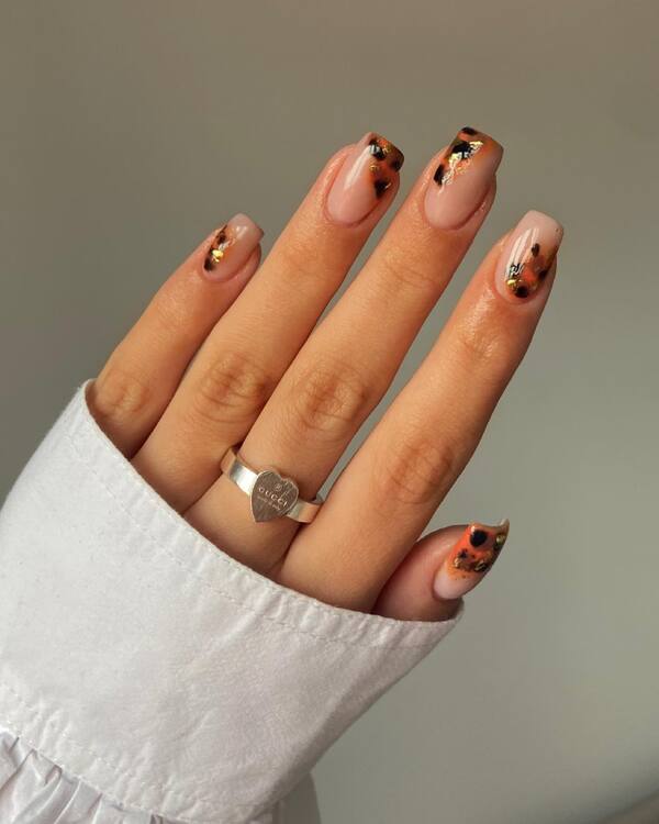 Tortoiseshell nail tips with gold accents, chic fall design.