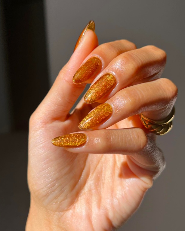 Golden glitter nails, stiletto shape, sparkling finish